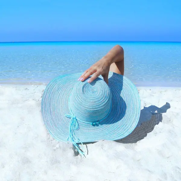 Woman on a beach with a hat